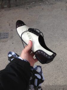 Un zapato blanco y negro, plano, estilo años 50 (lo que llamaban "saddle shoes")